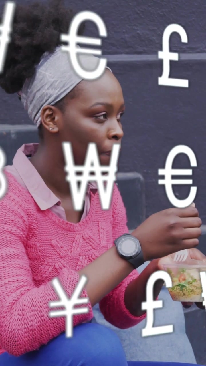 Video verticale: Donna che pranza mangiando da una ciotola mentre simboli finanziari fluttuanti le coprono il viso o la mano.
