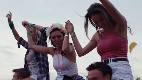 jóvenes amigos sobre hombros en un festival de música