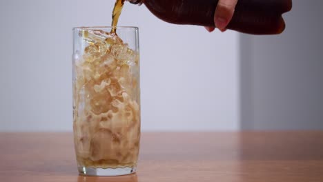 a hand pours a cool drink over ice showcasing a refreshing moment a modern kitchen