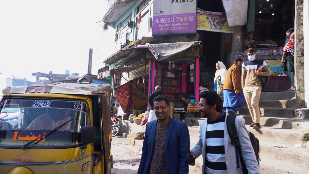 locals walking near shops and a rickshaw passing by in a bustling street, Muzaffarabad, Azad Kashmir