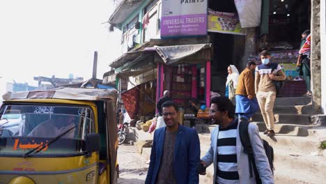locals walking near shops and a rickshaw passing by in a bustling street, muzaffarabad, azad kashmir