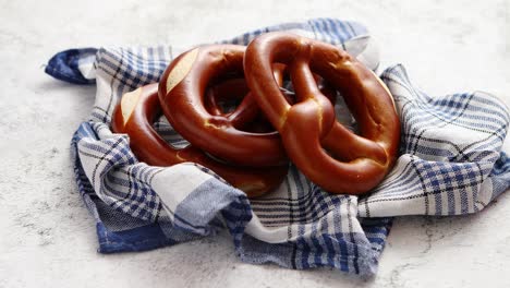 three german fresh baked pretzel buns placed on napkin