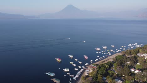 Boats-motor-on-deep-blue-water-of-mountain-Lake-Atitlan,-GTM-volcano