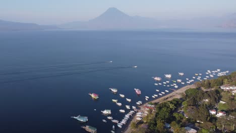 boats motor on deep blue water of mountain lake atitlan, gtm volcano