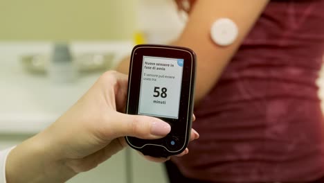 doctor with an insulin pump connected in patient abdomen and holding the insulin pump at his hands. diabetes concept.