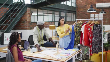 happy diverse fashion designers wearing the tape measures discussing work at office