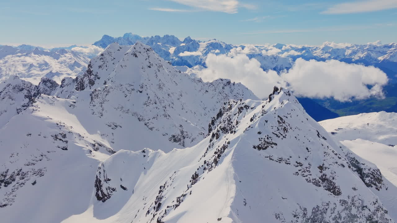 Aerial footage of the iconic freeride paradise of Verbier on a stunning bluebird day. Snow-covered peaks, wide open faces, and legendary off-piste terrain under clear alpine skies