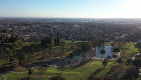 drone shot flying away from the lake at the la mirada regional park