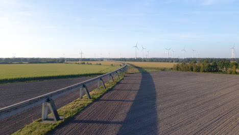 Vía-De-Prueba-Transrapid-Maglev-Elevada-Sobrevuelo-Con-Turbinas-De-Energía-Eólica-En-Segundo-Plano-En-Emsland,-Alemania