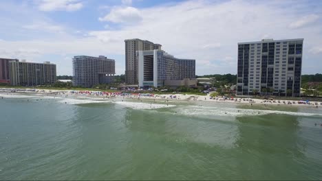 Drone-flying-low-above-the-water-on-a-sunny-day-in-the-summer-near-a-beach