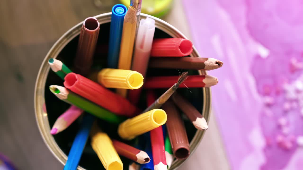 A cup with multiple colored pencils and markers