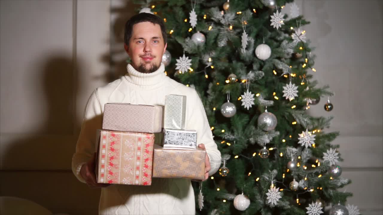 Man with Christmas Presents near a Christmas Tree