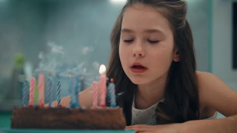 retrato de una niña soplando velas en cámara lenta. concepto de feliz cumpleaños para niños