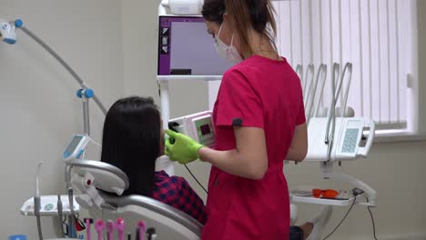 joven dentista tomando una radiografía de la mandíbula usando un dispositivo portátil. filmado en 4k