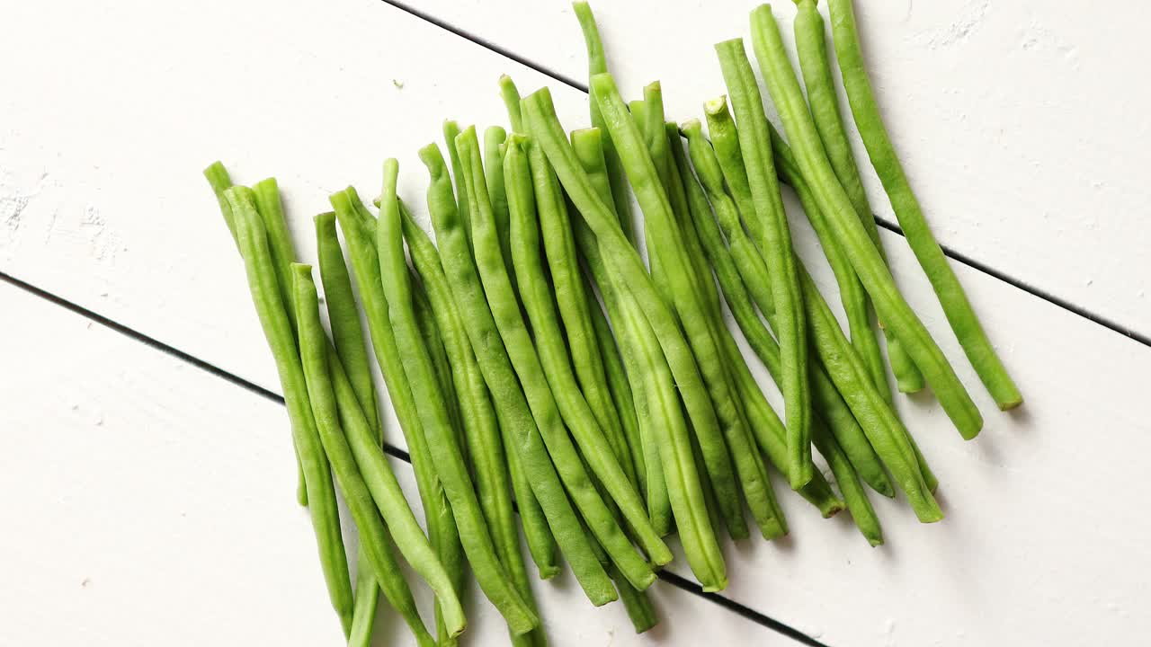 흰색 나무 테이블에 놓인 신선한 녹색 콩 꼬투리