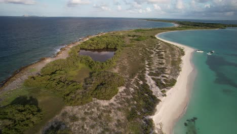 Aerial shot of lush green islands, blue water, and a sunset view over the coastline