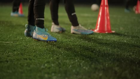 a children's football team trains at the stadium under the guidance of a coach. kids in sports uniforms practice ball exercises, improve technique, and develop teamwork on the green field