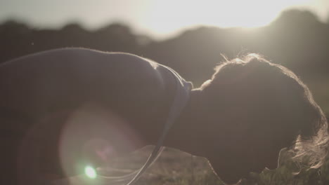 fotografía de cerca de un joven atractivo haciendo flexiones en el parque durante la hora dorada - sin calificar