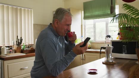 Älterer-Mann-Benutzt-Mobiltelefon,-Während-Er-Zu-Hause-Kaffee-Trinkt