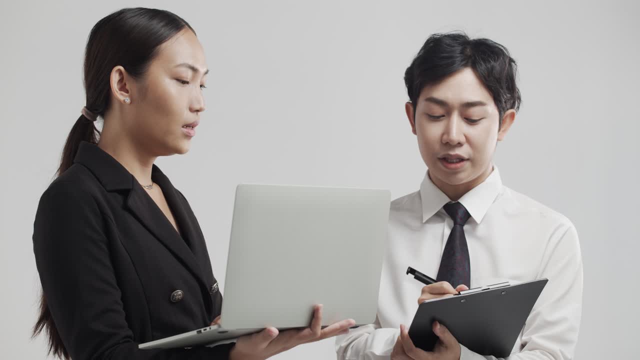 Asiatisk mand og kvinde diskuterer et forretningskoncept som et team - isoleret med hvid baggrund