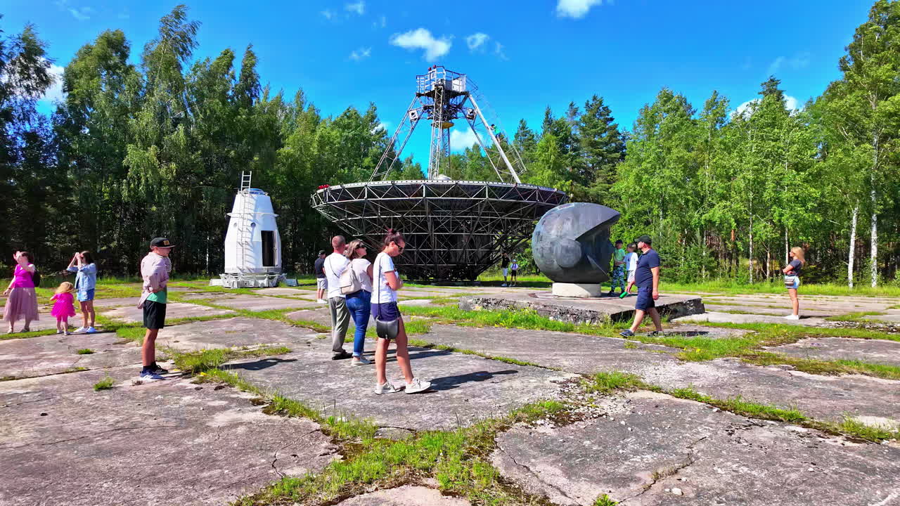 People visiting an abandoned radio telescope and art installation