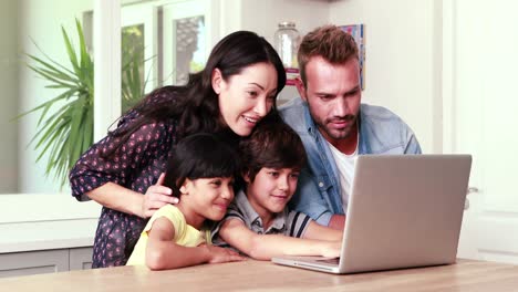 smiling family using laptop
