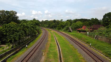 drone view of a two lane train rail that divides the countryside in indonesia