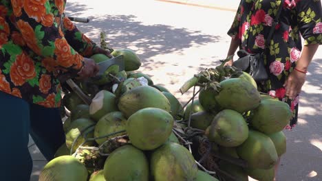 medium shot of chopping coconuts ready to sell