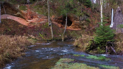 Cecilu-rock-formation-with-river-stream-in-Latvia,-aerial-dolly-forward