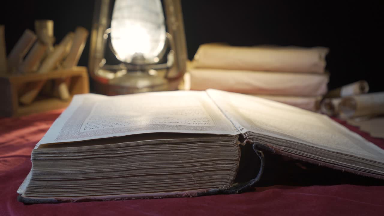 Libro storico alla luce di una vecchia lampada a olio