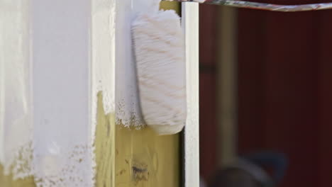 applying white paint with a paint roller