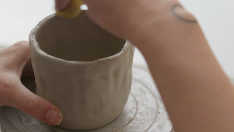 Mit-Einem-Drehrad-Und-Einem-Schwamm-Gelingt-Es-Ihm,-Ton-Meisterhaft-Zu-Einer-Tasse-Zu-Formen-–-Eine-Faszinierende-Demonstration-Seines-Könnens