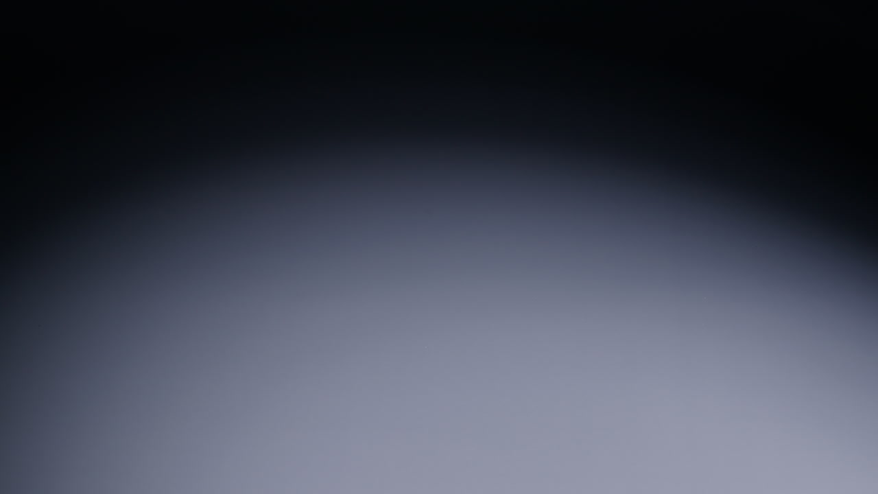 Slow-motion wide shot as four dice roll from screen right to middle and stop