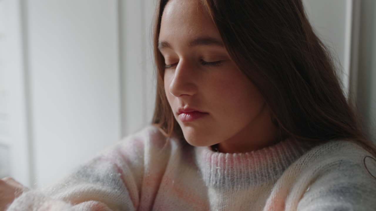 슬픈 십대 소녀는 집에서 울고 혼자 느끼고 우울한 십대는 감정적 인 헤어짐을 생각하고 침실에 앉아 있습니다.