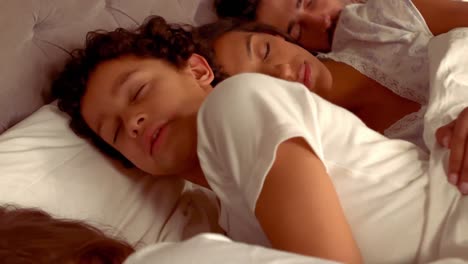 la familia hispana duerme en la cama