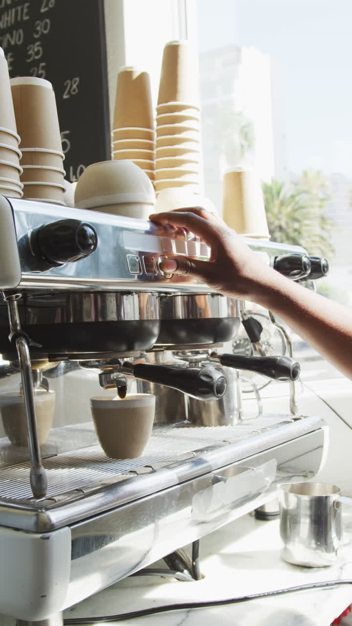 video vertical de la mano preparando café en la máquina de café en la cafetería