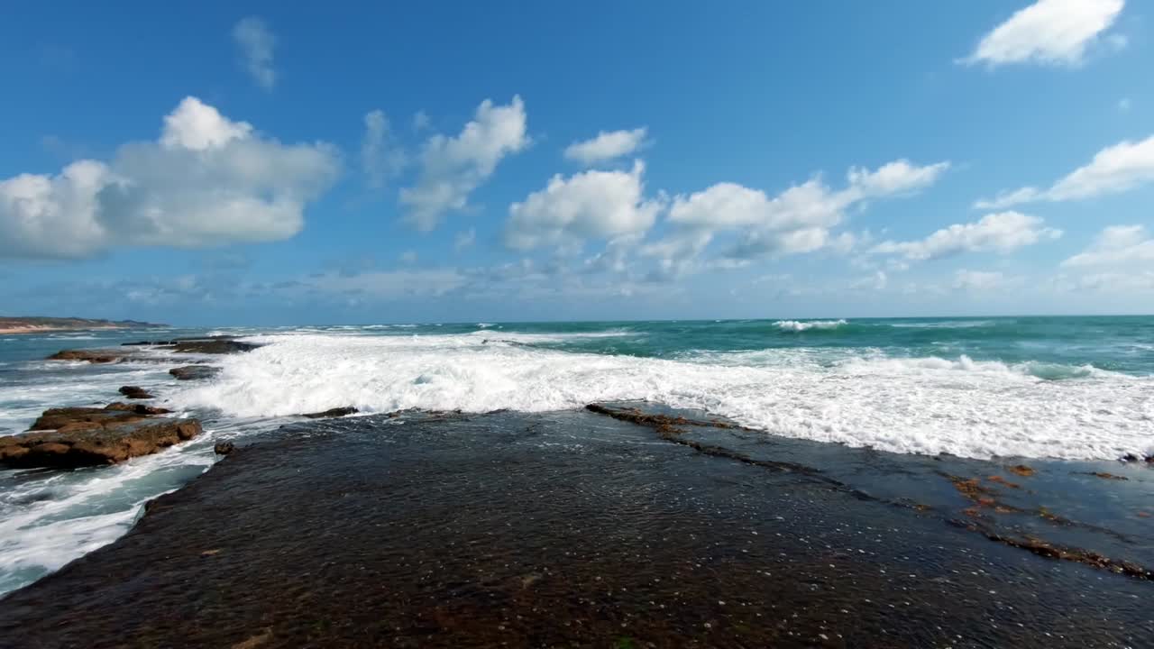 olas rompiendo contra las rocas en la hermosa playa tropical brasileña de sibauma cerca de pipa en rio grande do norte, brasil en un cálido y soleado día de verano
