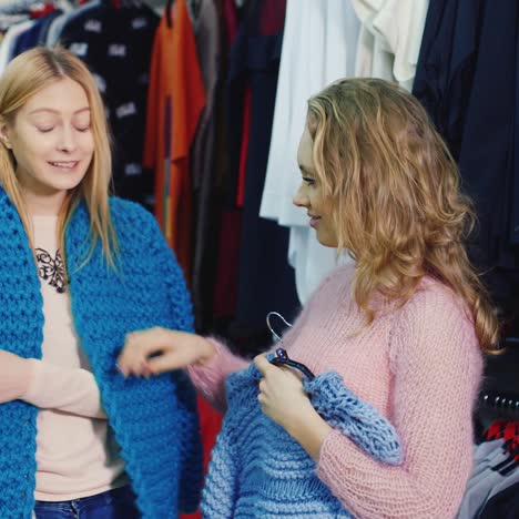 two friends choose warm winter clothes in the store 3