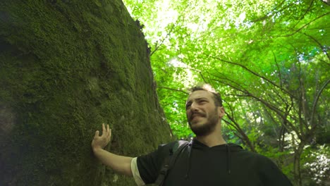 el joven está llorando en el bosque.