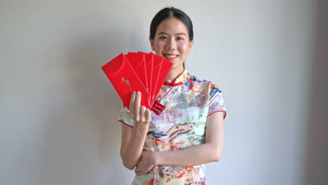 Hermosa-Mujer-Asiática-Usa-Un-Vestido-Tradicional-Chino-Con-Sobre-Rojo-O-Paquete-Rojo