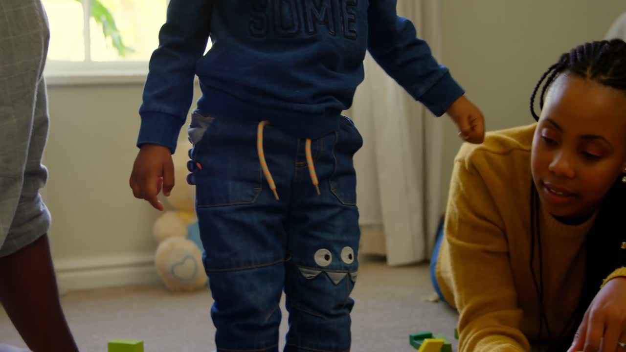 Font view of young black parents and son playing with toys in a comfortable home 4k