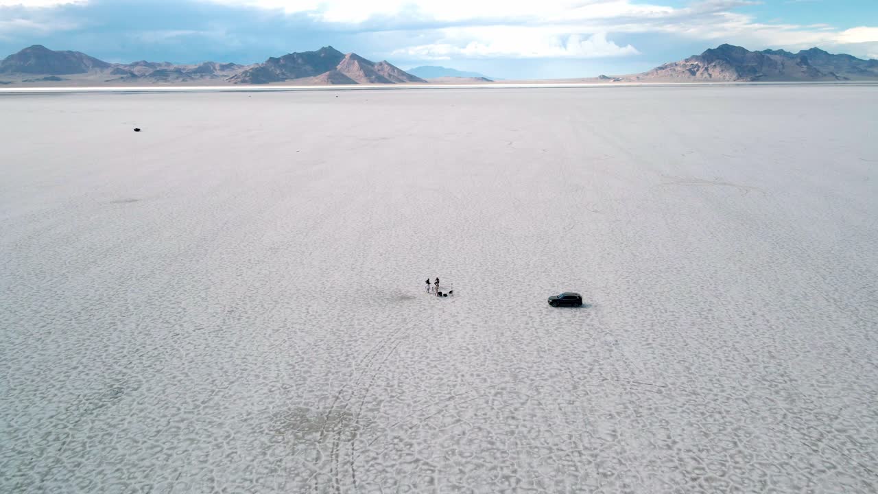 Cinematic establishing shot of film crew filming an interview in the middle of bonneville salt flats utah near nevada border aerial footage 4k