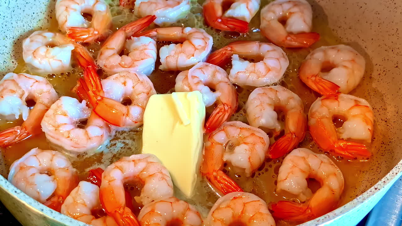 Cooking delicious shrimp with butter in hot pan, close up
