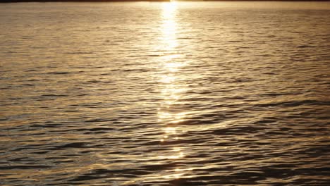 Cámara-Lenta-De-Agua-Al-Atardecer-Con-El-Sol-Reflejado