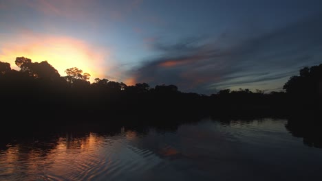 puesta de sol extremadamente hermosa sobre el lago oxbow con ondas en el agua y colores brillantes en el cielo
