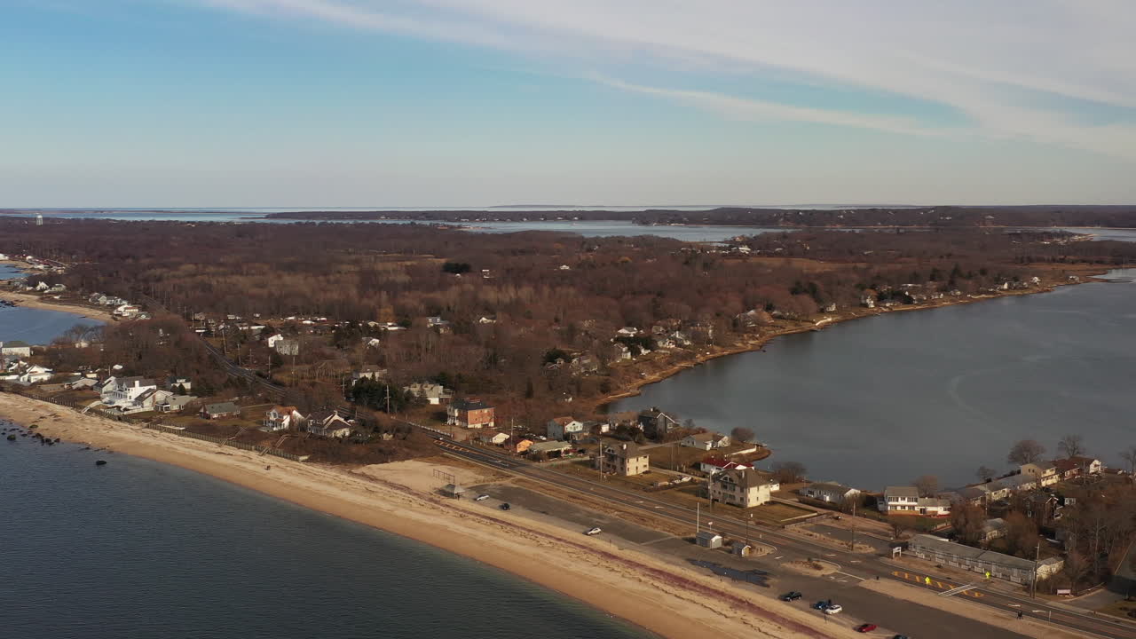 una vista de ángulo alto sobre las aguas tranquilas en una playa vacía, en un día con cielos azules