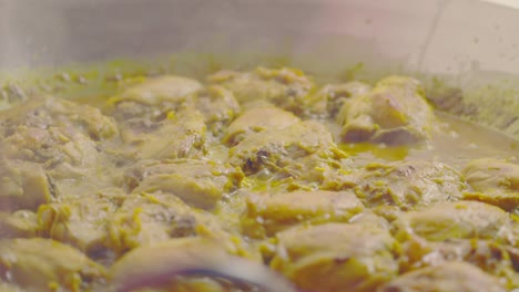 añadiendo arroz amarillo encima del pollo cocido