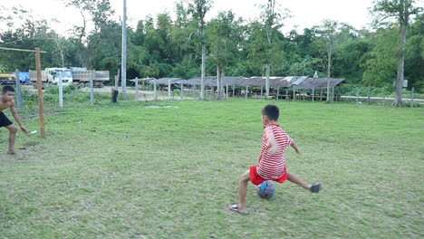 boys playing soccer in a rural field