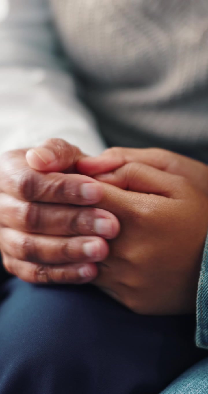 Close-up of Two People Holding Hands in Support