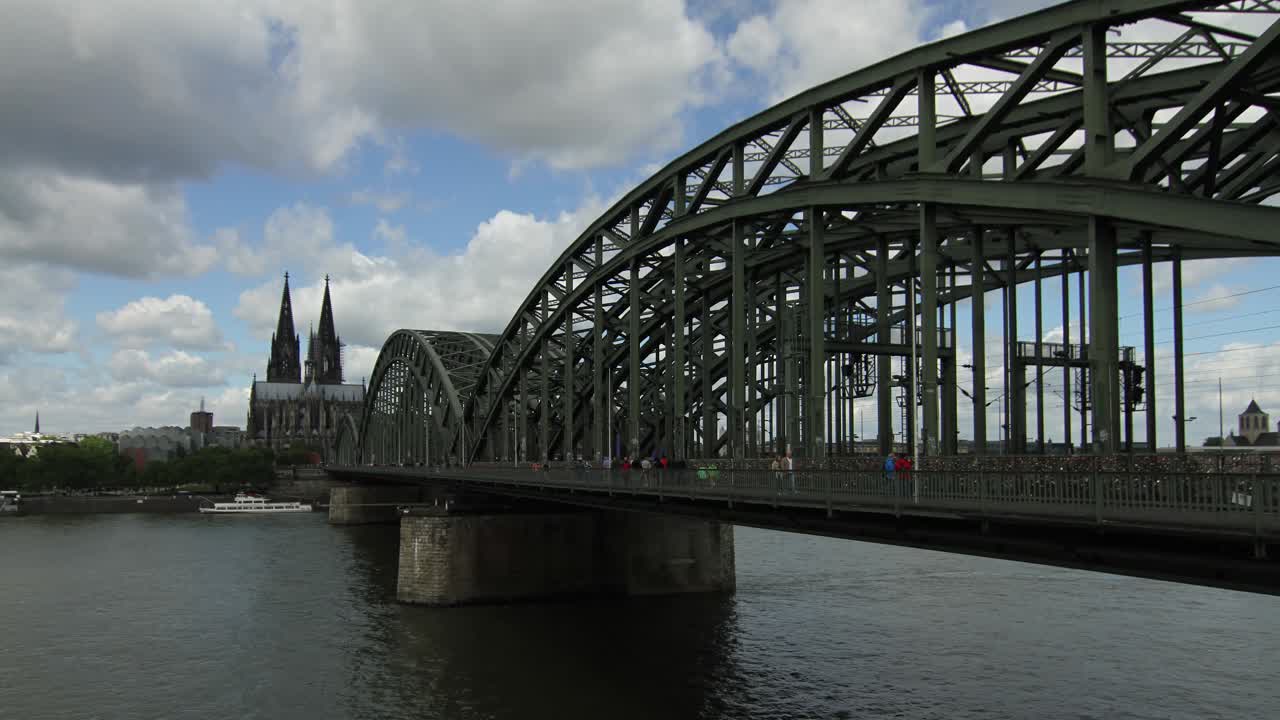 A 4k Timelapse of the hohenzollernbrucke - Love Locks Bridge in Cologne, Germany against white clouds and blue skies.